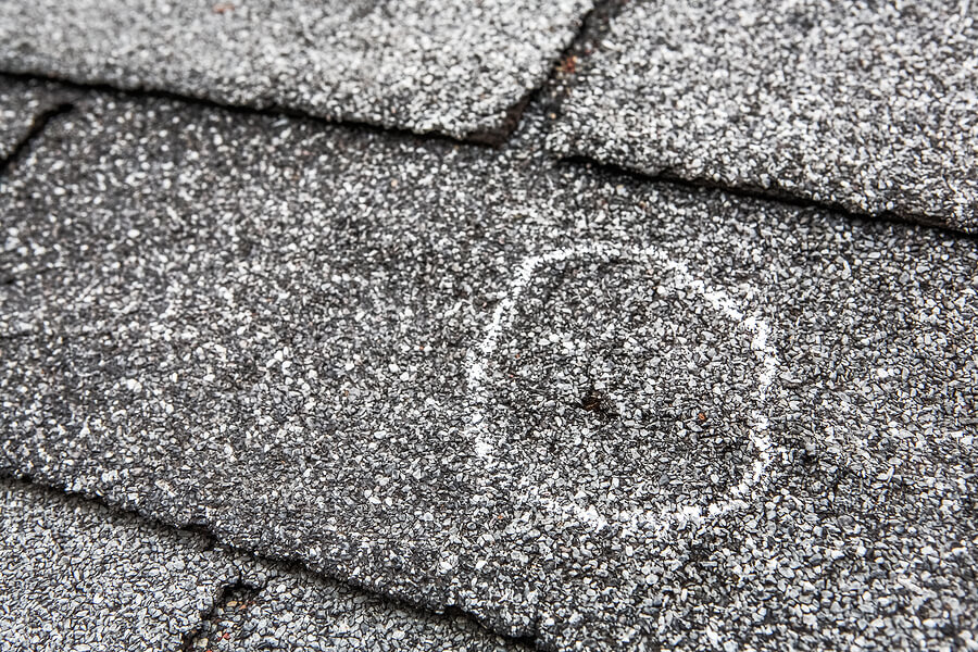 Close-up of a hail dent in an asphalt shingle. 